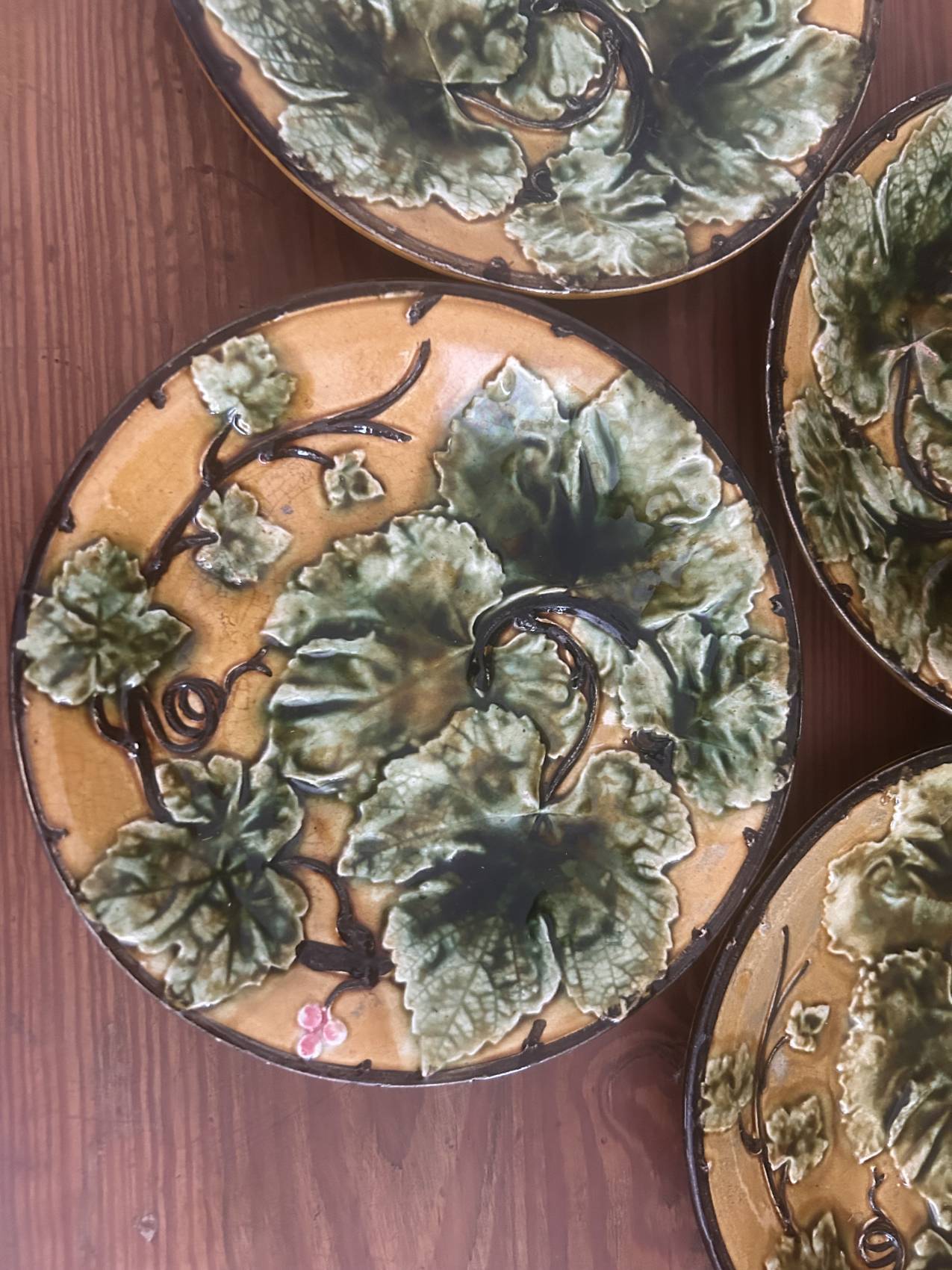 Four antique dessert plates in majolica with vine decoration.