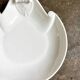 Small, shallow porcelain dish shaped like a seashell