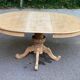 Extendable round dining table with central art deco leg, renovated in raw wood