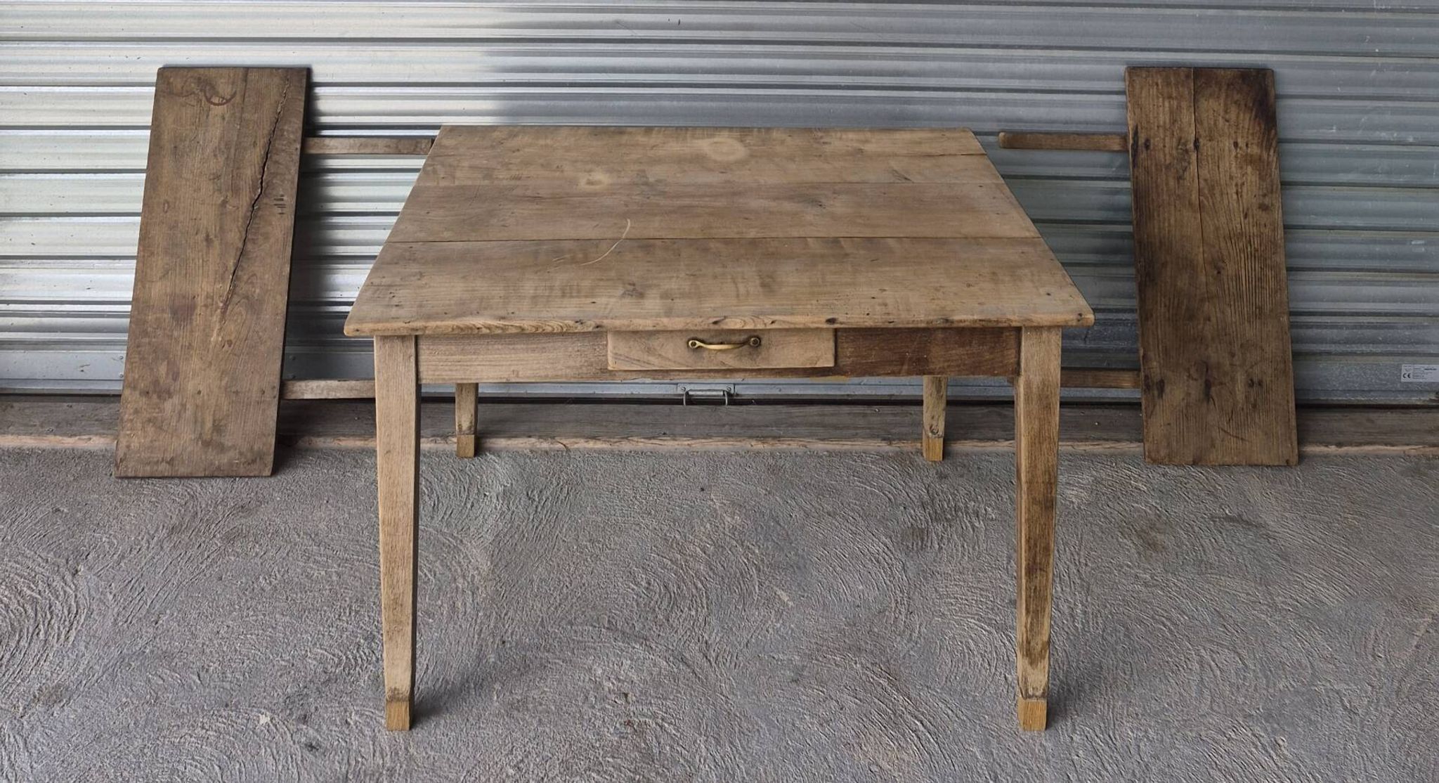 Old farmhouse table with its 2 extensions and raised legs.