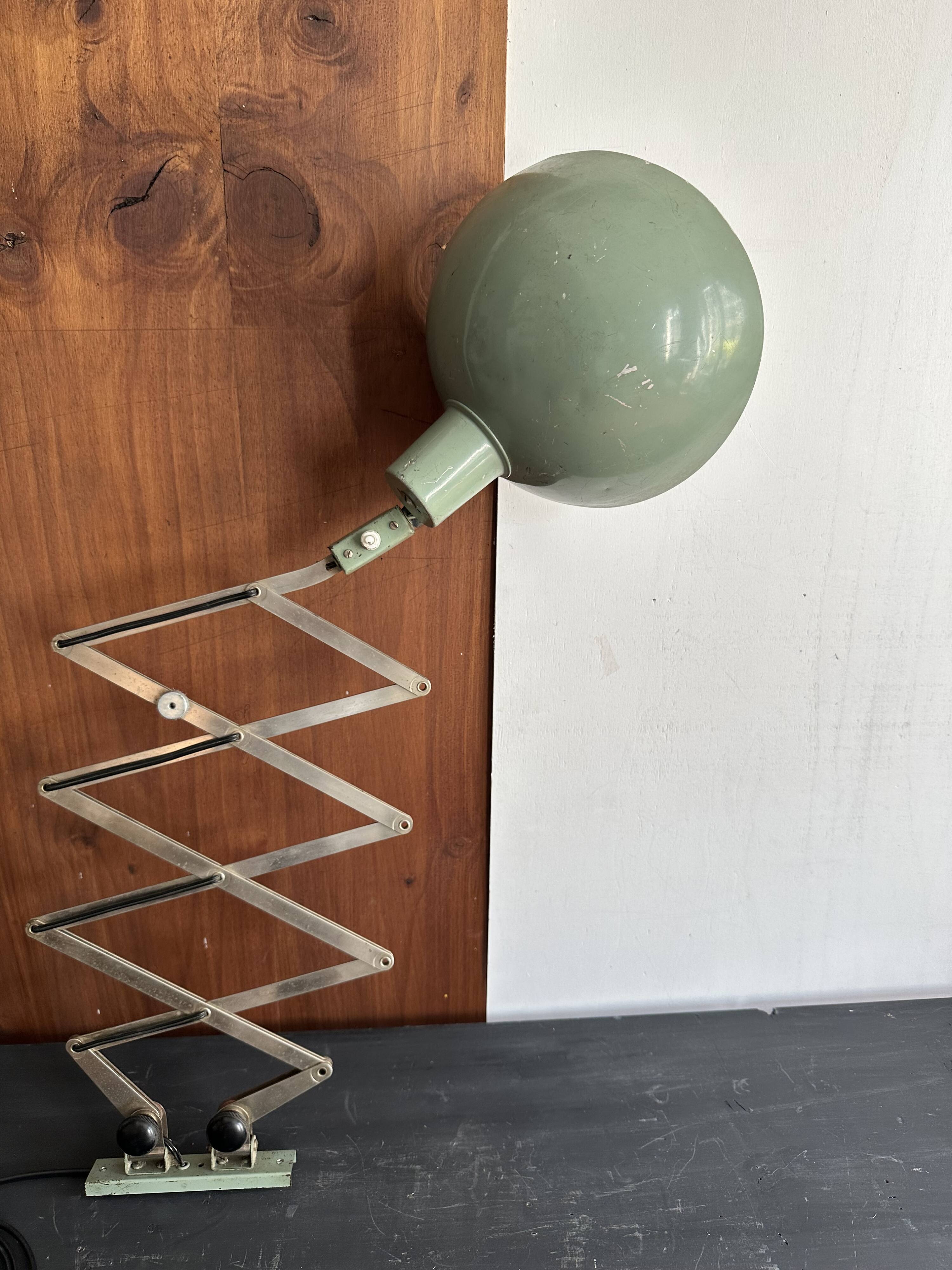 Old extendable accordion lamp in celadon green, workshop spirit.