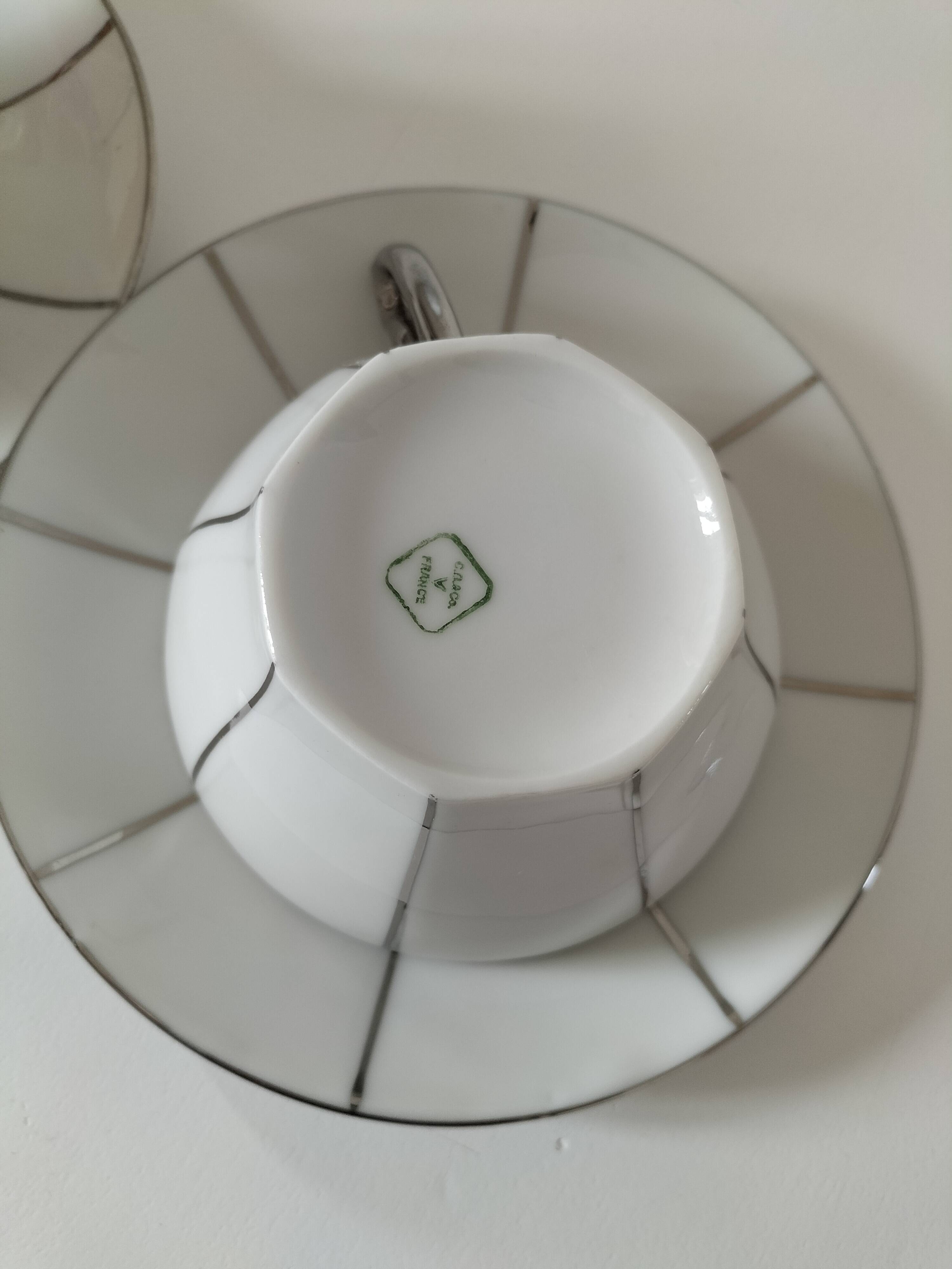 Two Art Deco porcelain cups and saucers with silver trim.