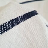 Handwoven throw with black stripes and pom-poms