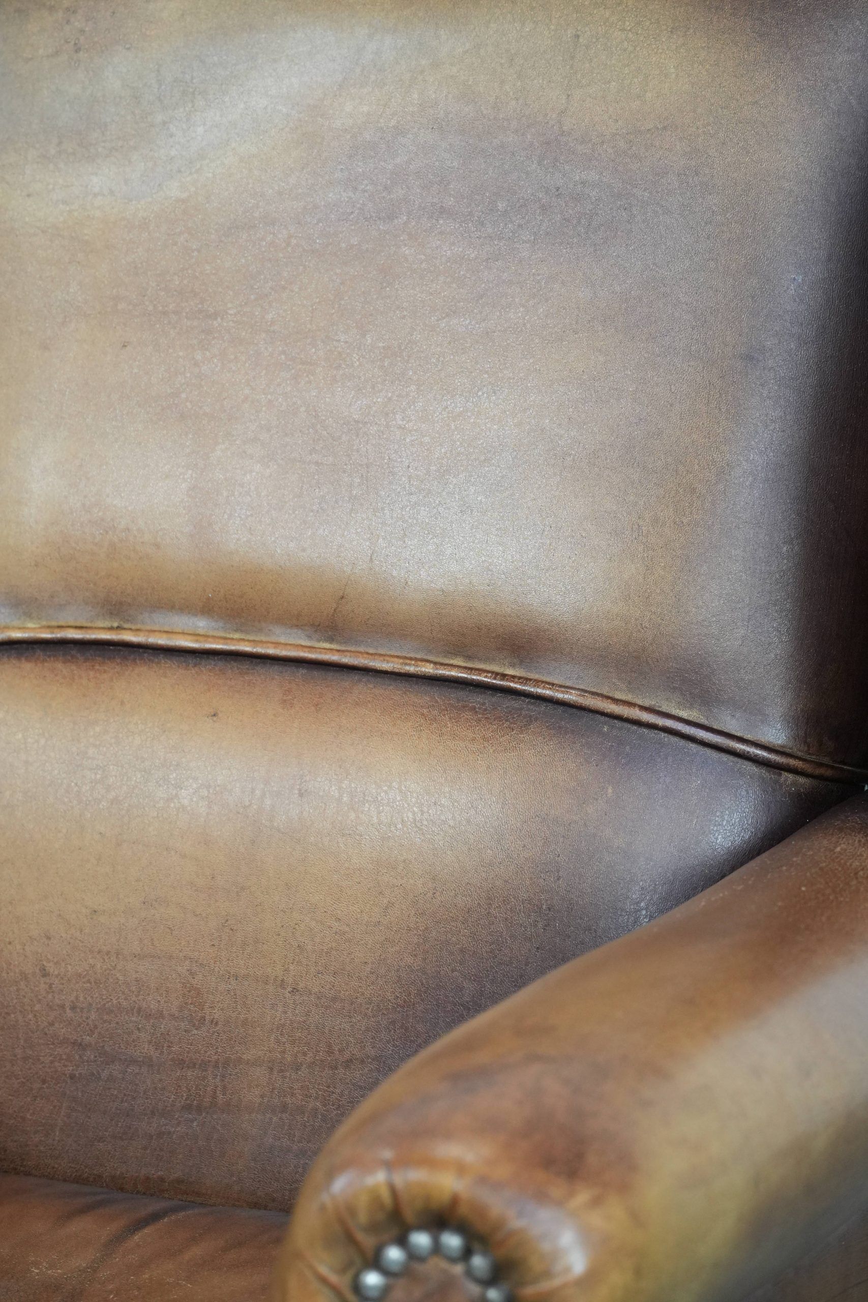 Fauteuil à oreilles en cuir de mouton charmant avec des couleurs chaudes.