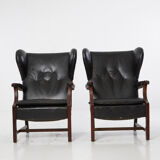 Pairs of black leather Scandinavian armchairs