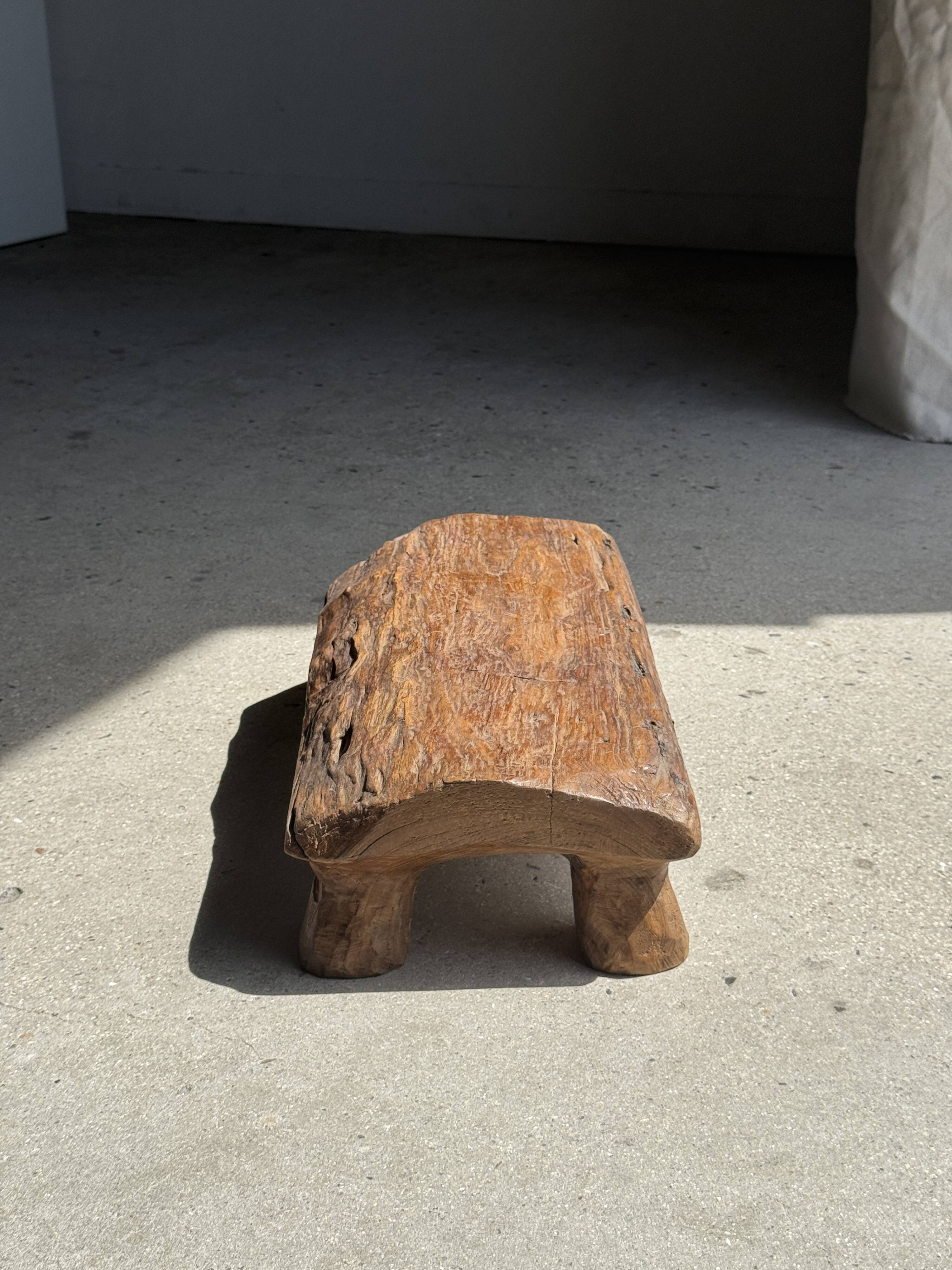 Small stool, footrest in blond teak, organic monoxyle with cut corners.