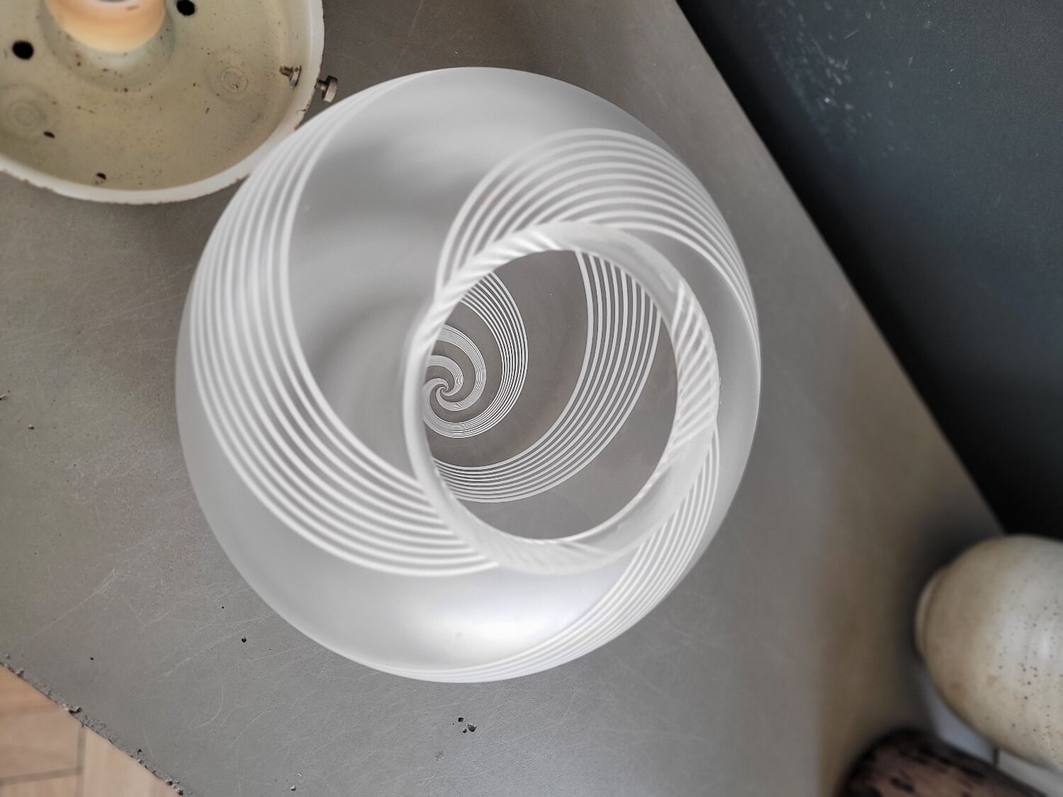 Frosted glass globe ceiling light with spiral patterns.