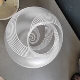 Frosted glass globe ceiling light with spiral patterns.