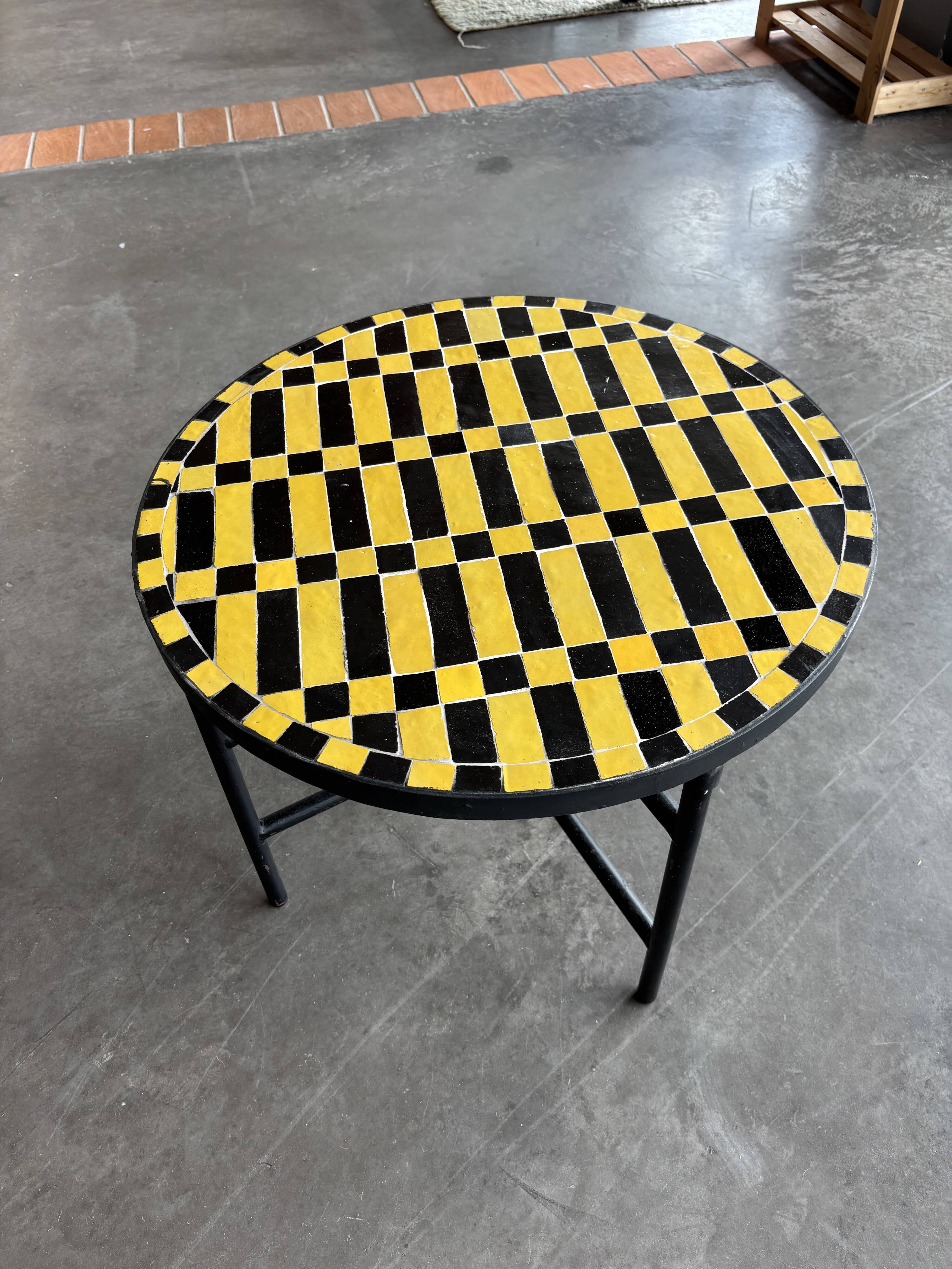 Round coffee table in yellow and black zellige, Moroccan graphic pattern.