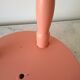 Coral-coloured turned wooden four-legged stool.