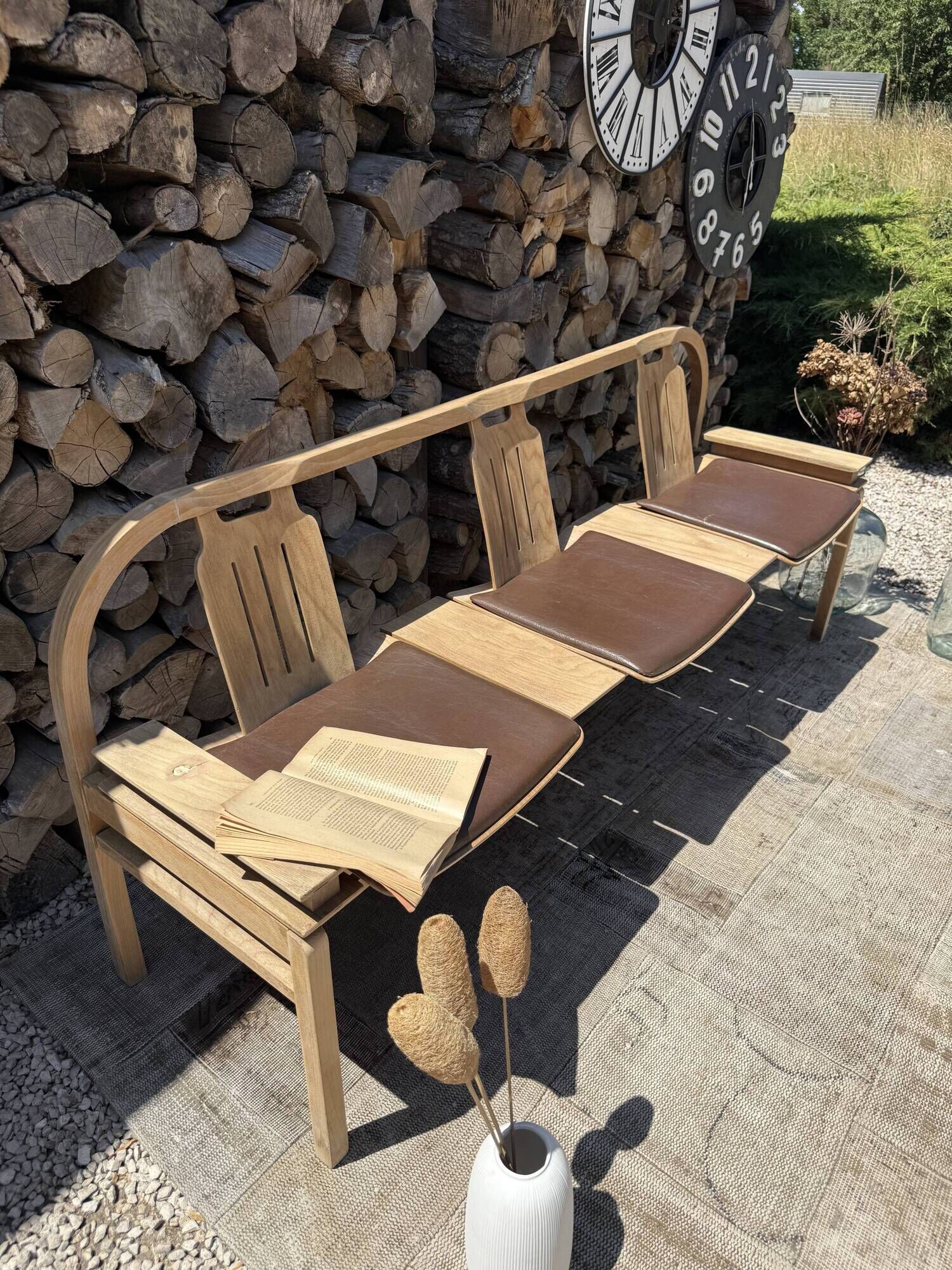 Baumann bench with wooden frame and faux leather seat.
