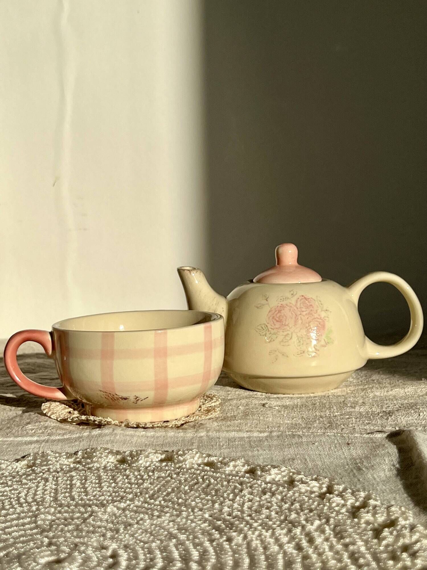 Vintage porcelain teapot and cup set with pink and beige floral and gingham pattern