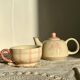 Vintage porcelain teapot and cup set with pink and beige floral and gingham pattern