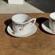 Pair of white porcelain cups from ADP France with a floral pattern and their s