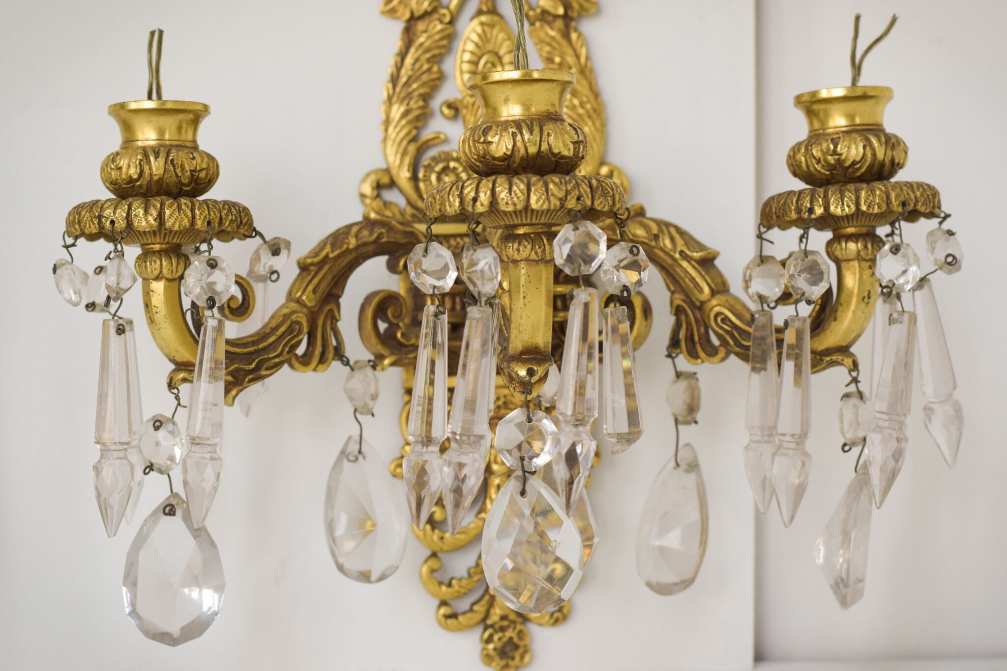Two bronze and cut glass wall-mounted chandeliers