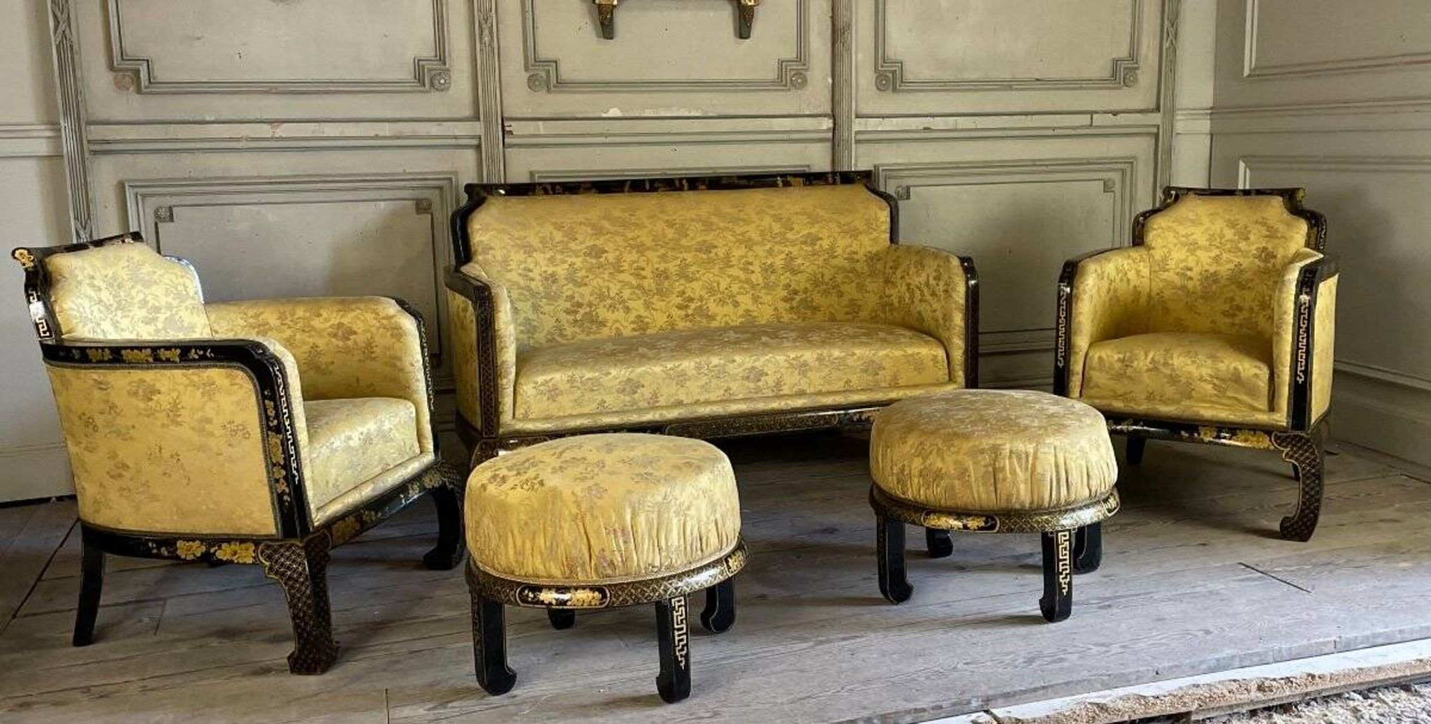 A set of two armchairs, a sofa and two poufs in lacquered wood with gilded chinoiserie decoration.