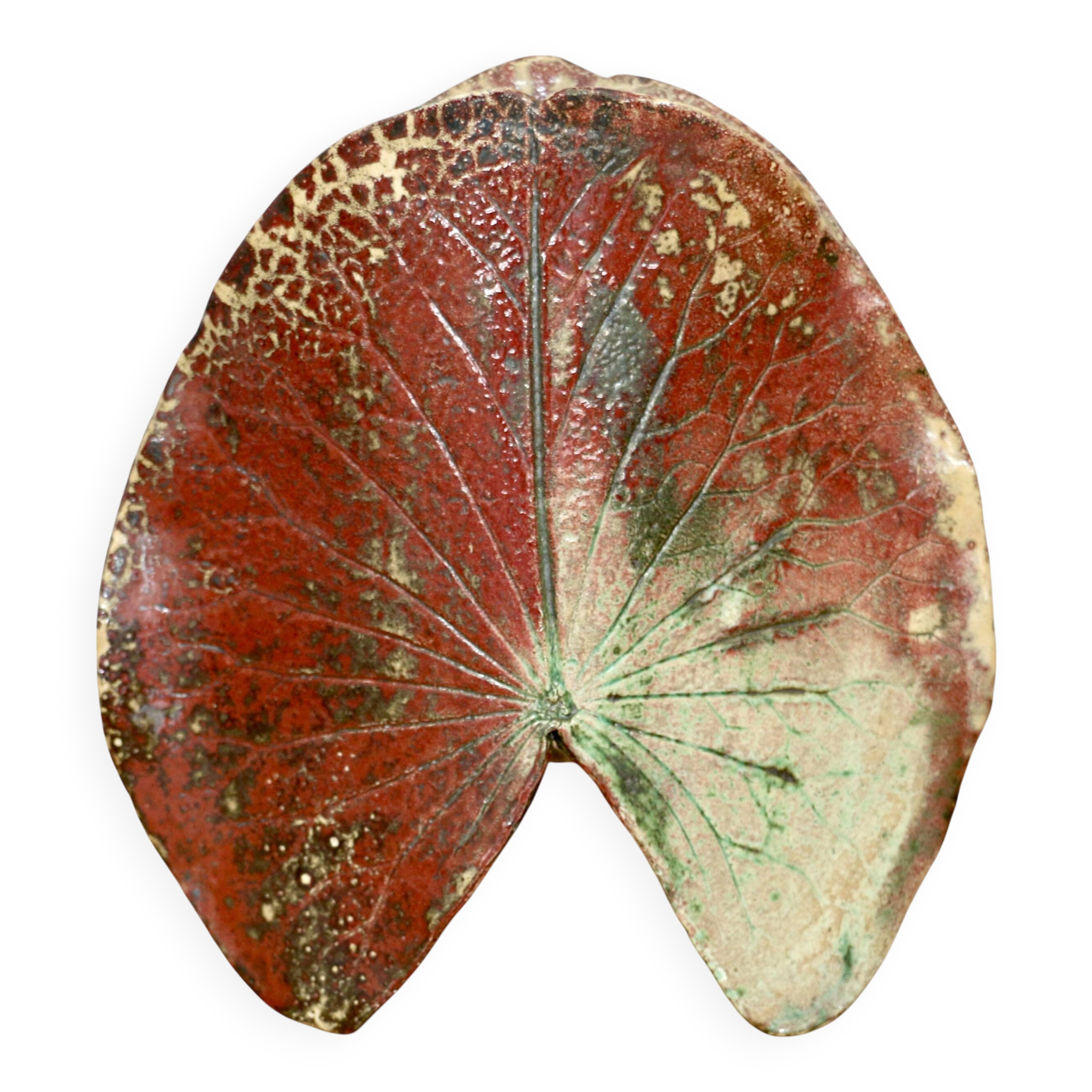 A ceramic lamp in the shape of a leaf.