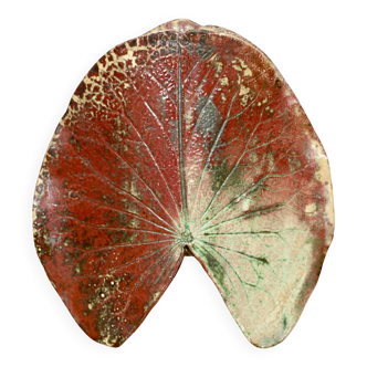 A ceramic lamp in the shape of a leaf.