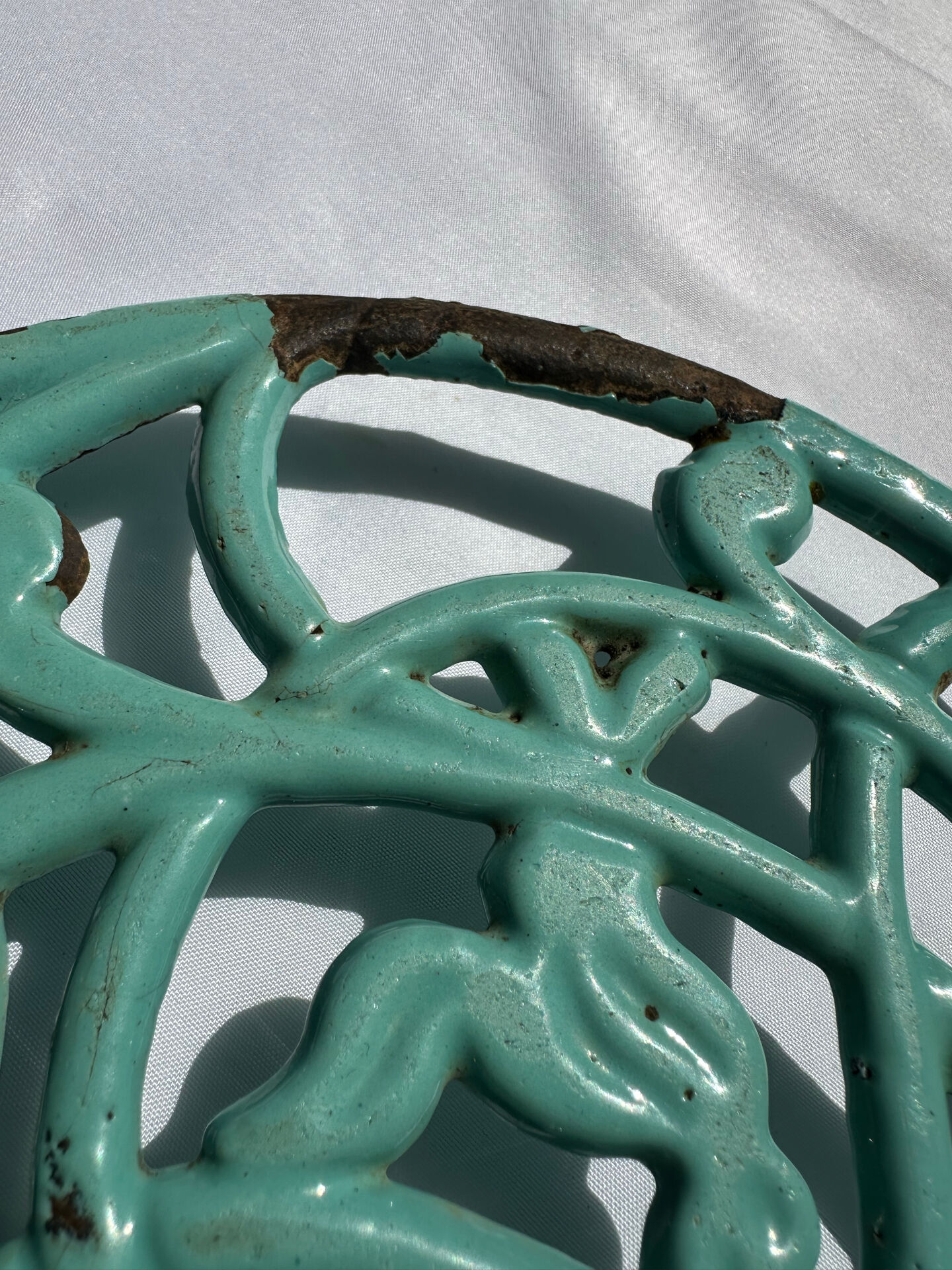 Enamelled cast iron trivet in blue with wrought iron decoration.