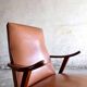Vintage armchair from the 1950s in cognac leather and dark wood — modernist lounge chair.