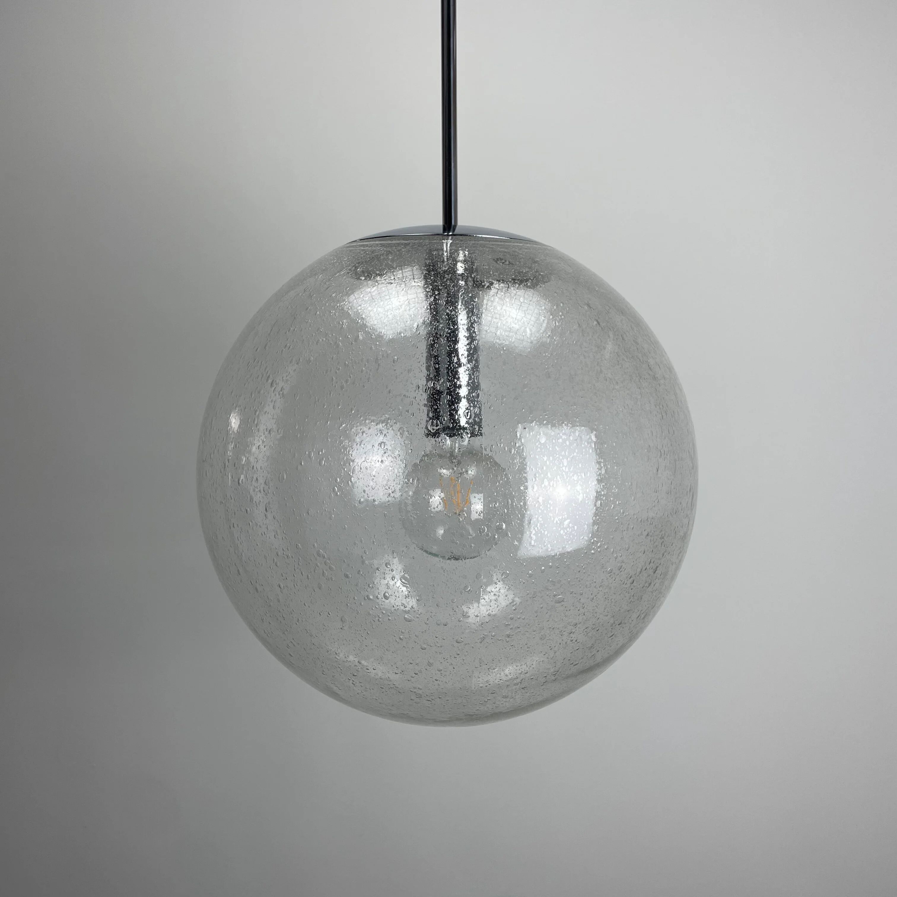 Large suspended lamp with a glass globe featuring bubbles by Peill & Putzler 1970.