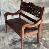 Small antique Indonesian bench in carved teak with plant and floral motifs.