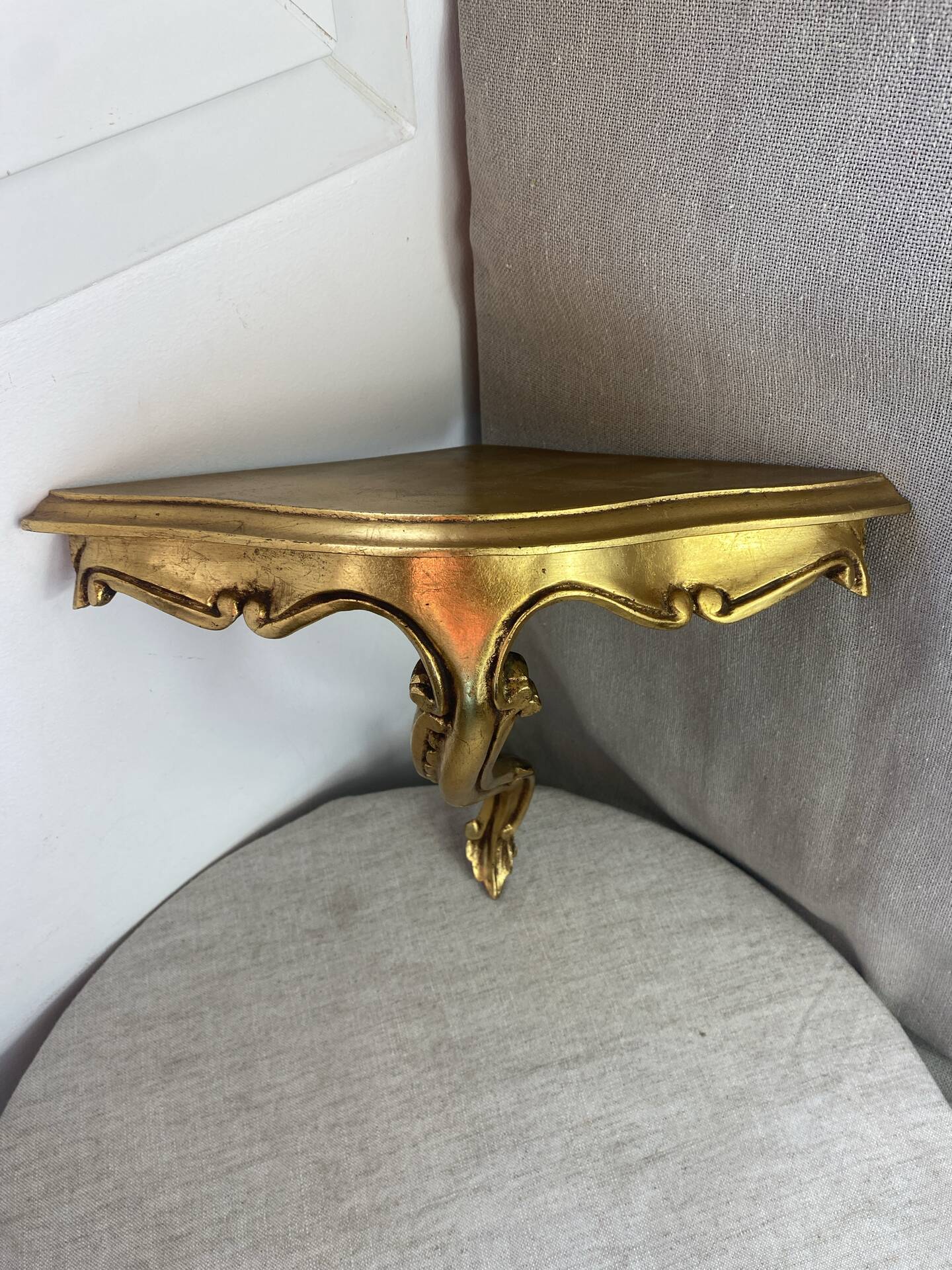 Small corner console in resin with a gold finish.