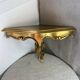 Small corner console in resin with a gold finish.