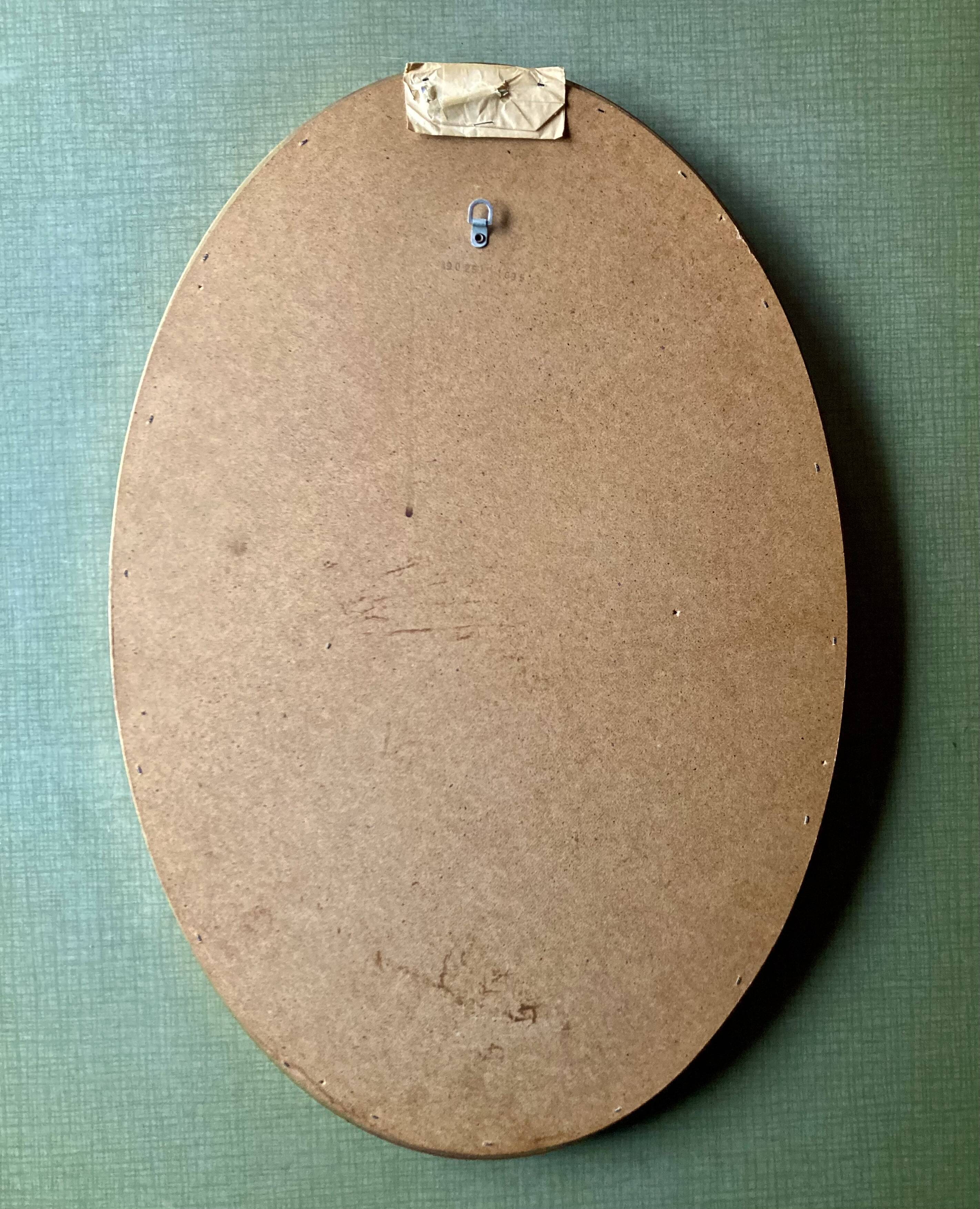 Old large oval wall mirror in golden resin