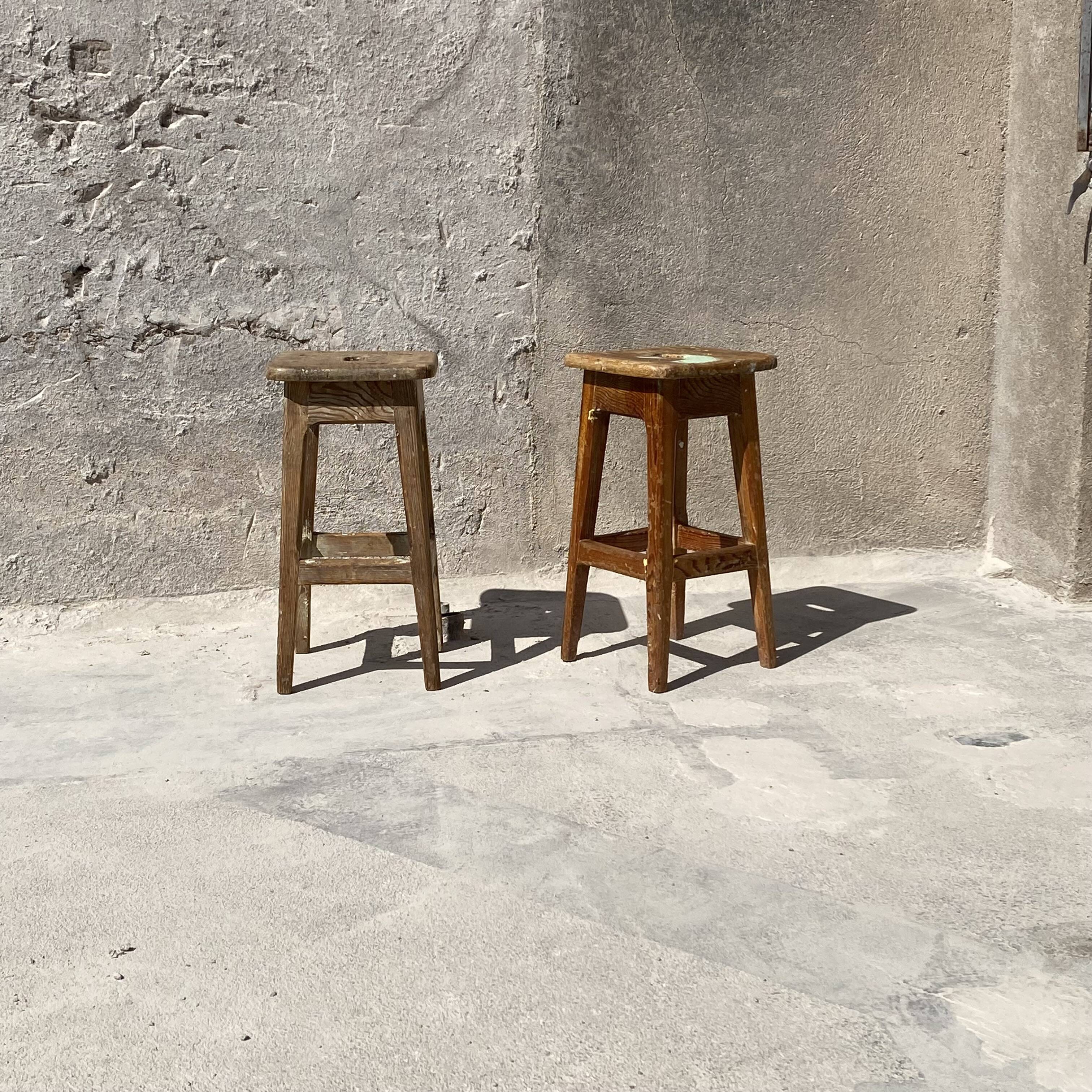 Pair of vintage wooden workshop stools with a patina.