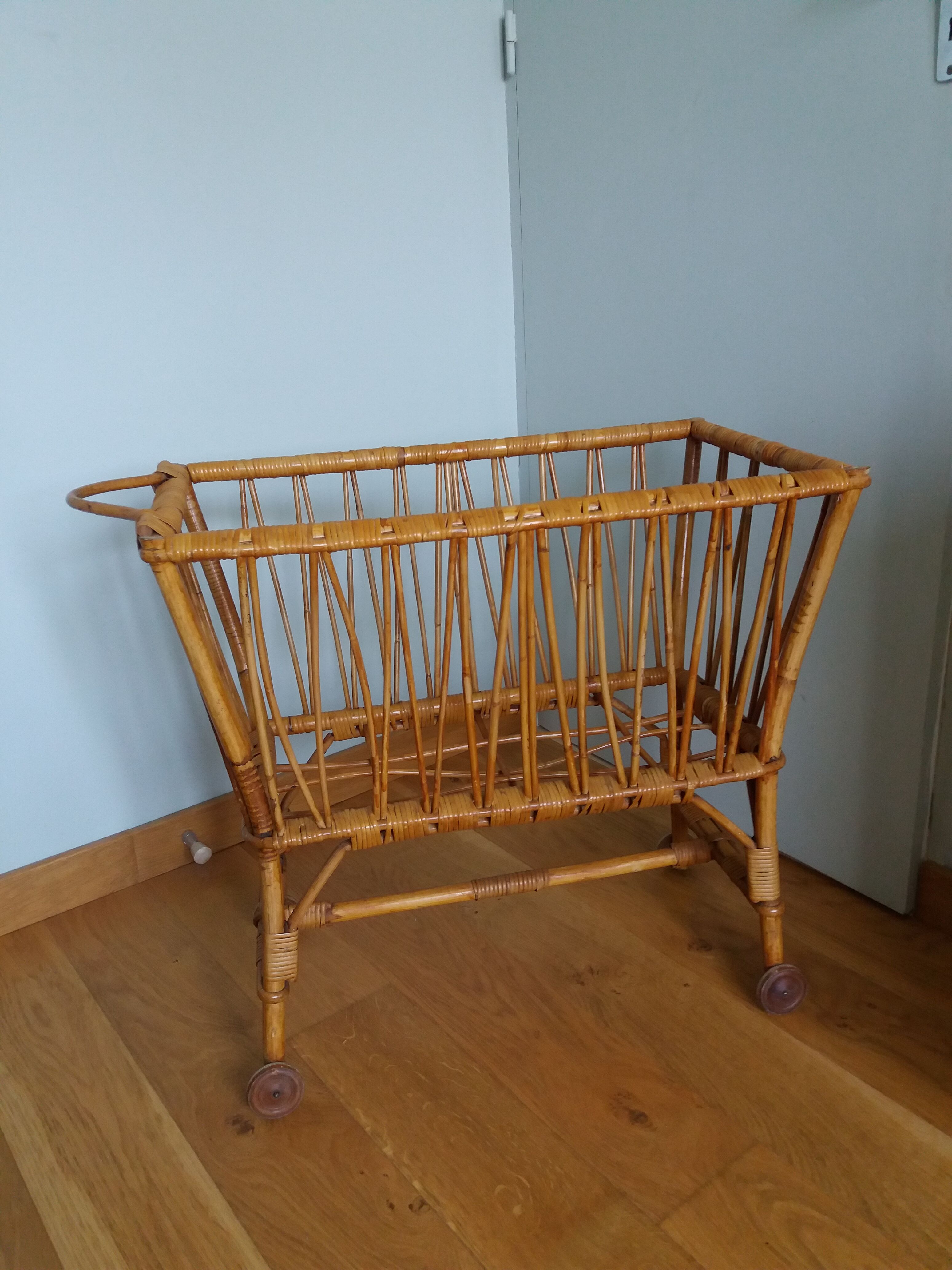 Rattan wicker cradle on wooden wheels