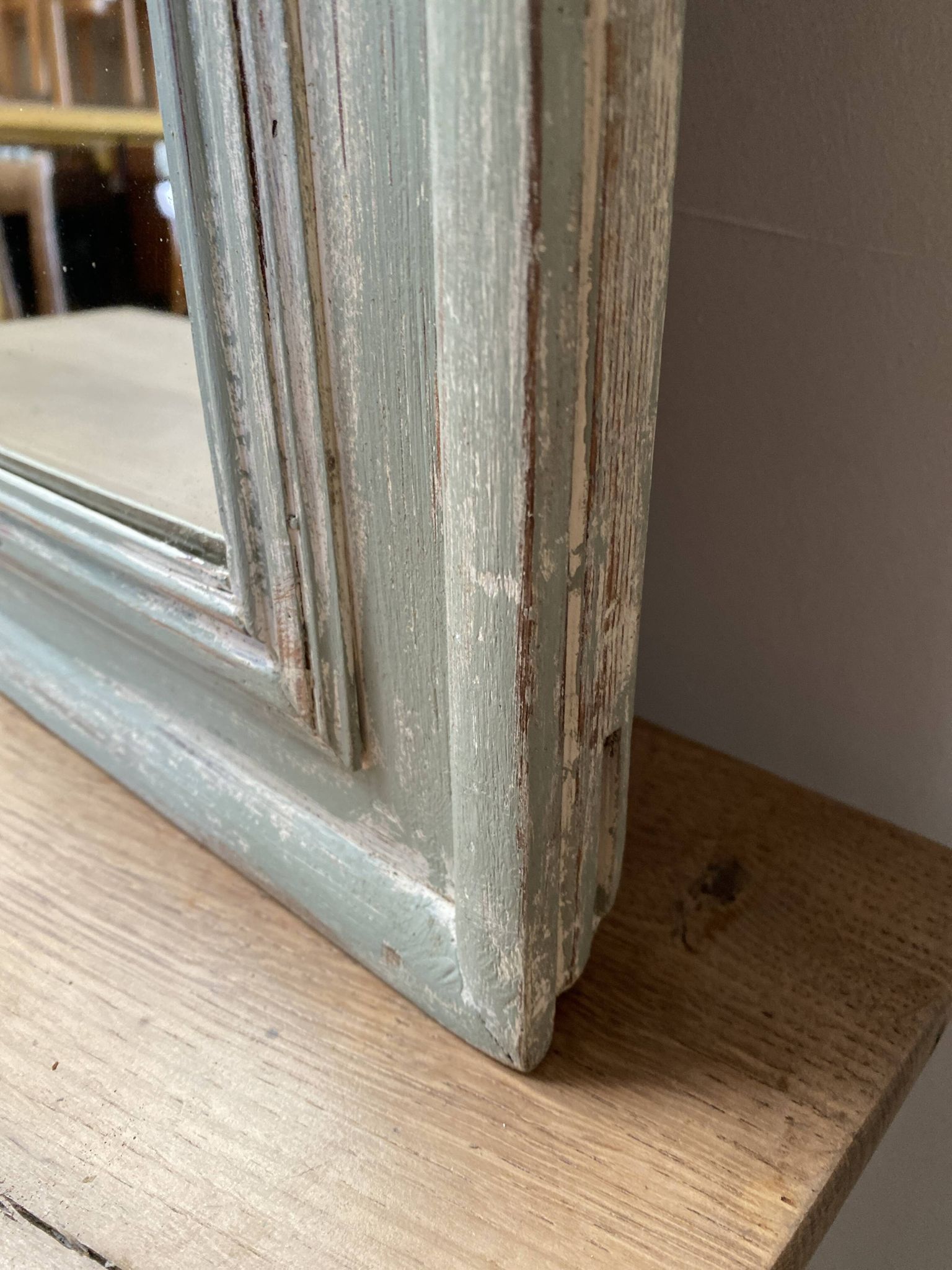 Antique mirror with a green and white patina.