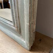 Antique mirror with a green and white patina.