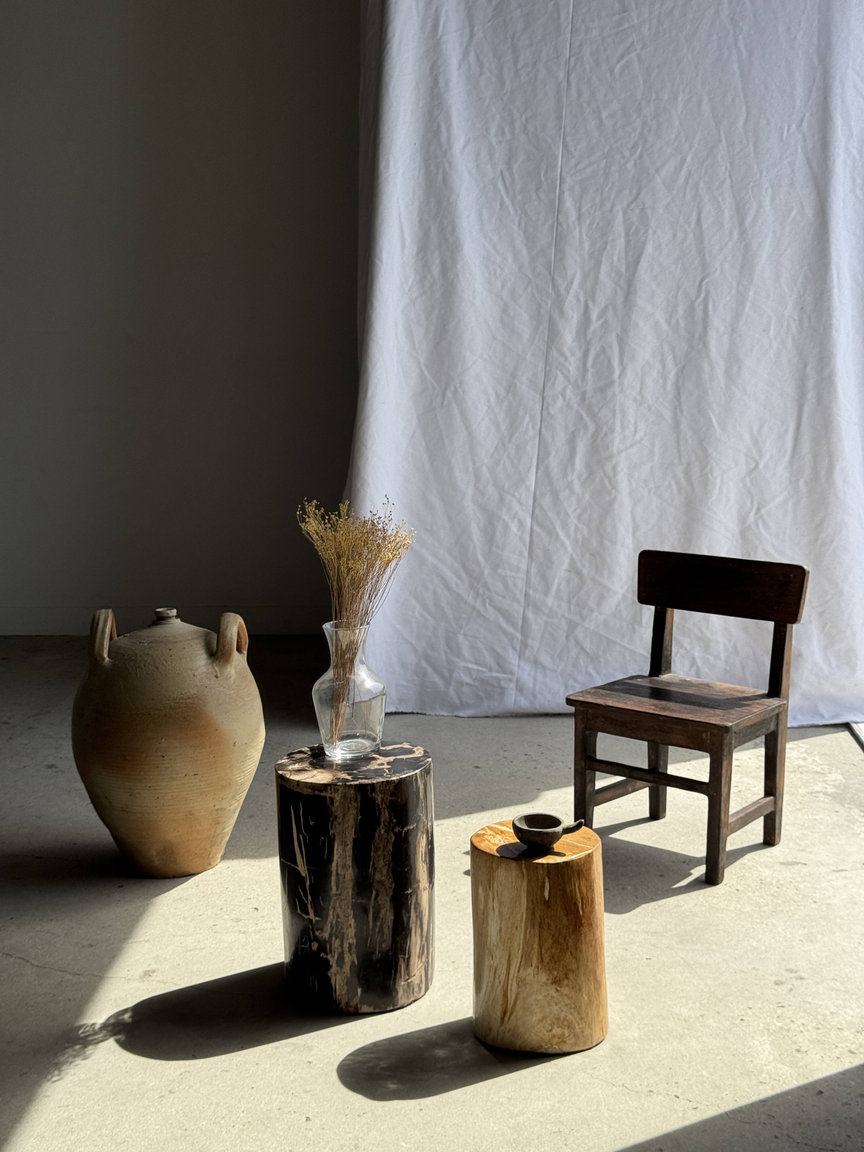 Black petrified wood side table with beige stripes and a semicircular shape.