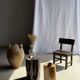 Black petrified wood side table with beige stripes and a semicircular shape.
