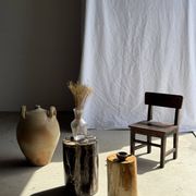 Black petrified wood side table with beige stripes and a semicircular shape.