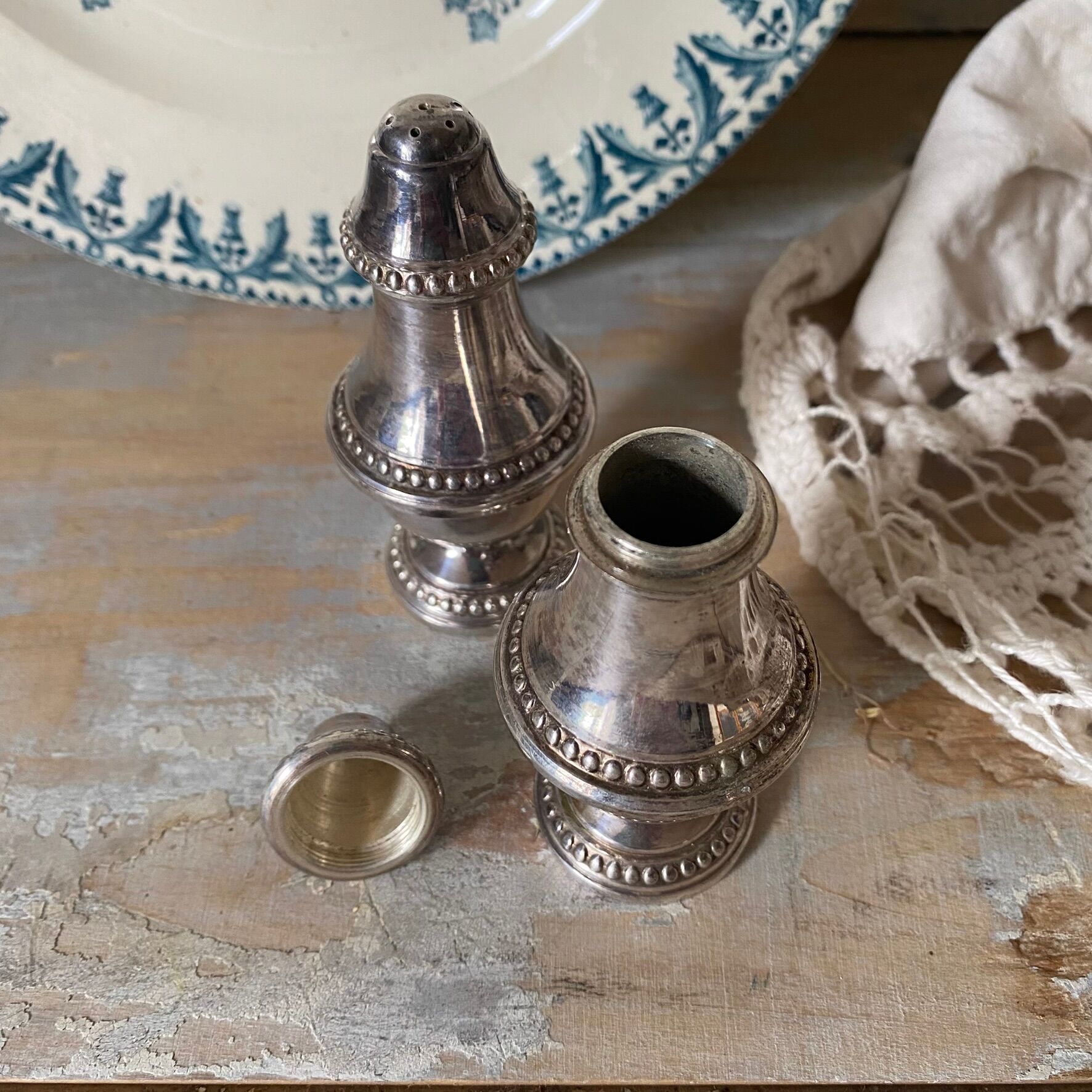 Silver-plated salt and pepper shakers, fluted, beaded decoration.