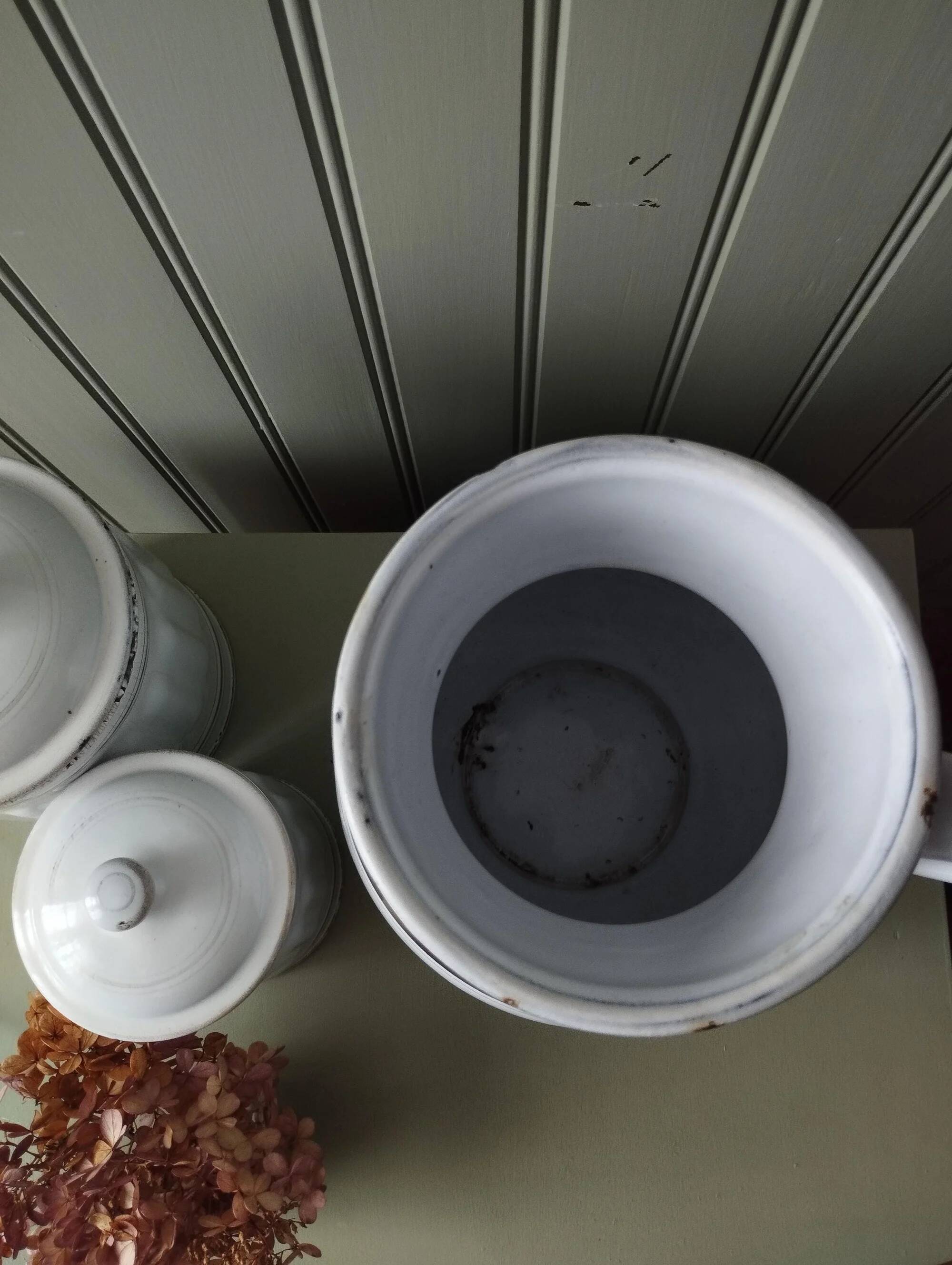 Old enamelled metal jug with gold trim.