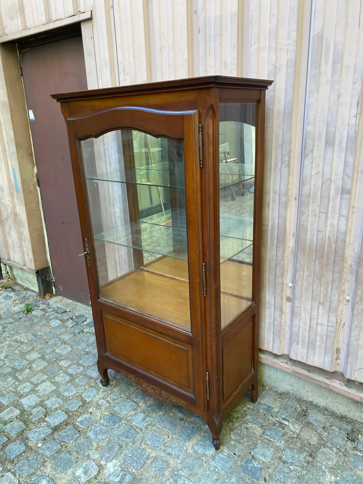 Louis XV style display cabinet in cherry wood with a mirrored back and glass shelves.