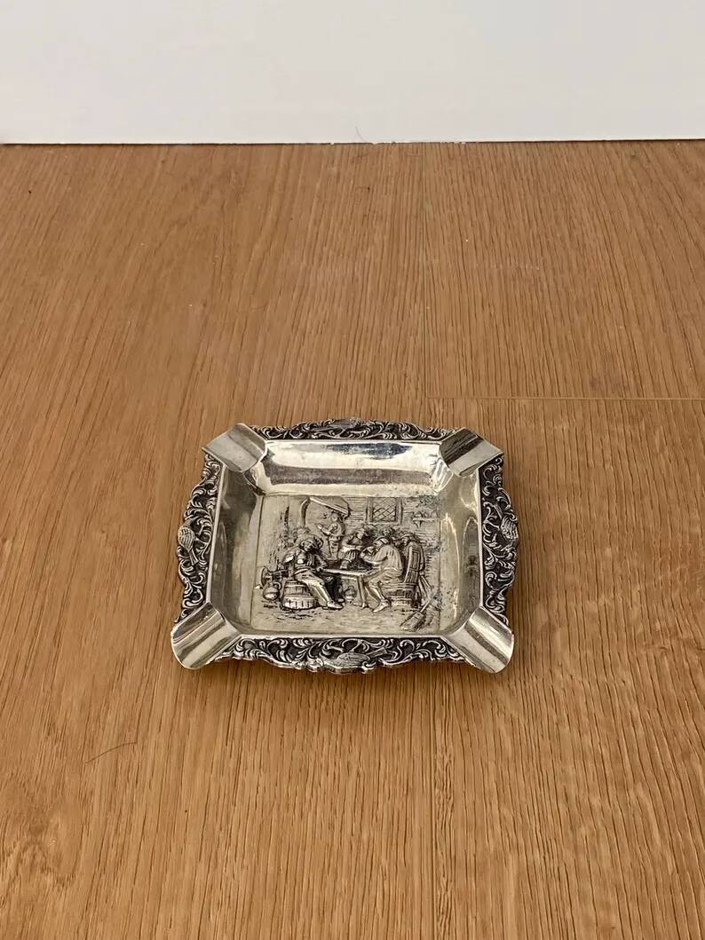 Antique silver-plated ashtray, decorated with repoussé scenes of a tavern, pin tray.