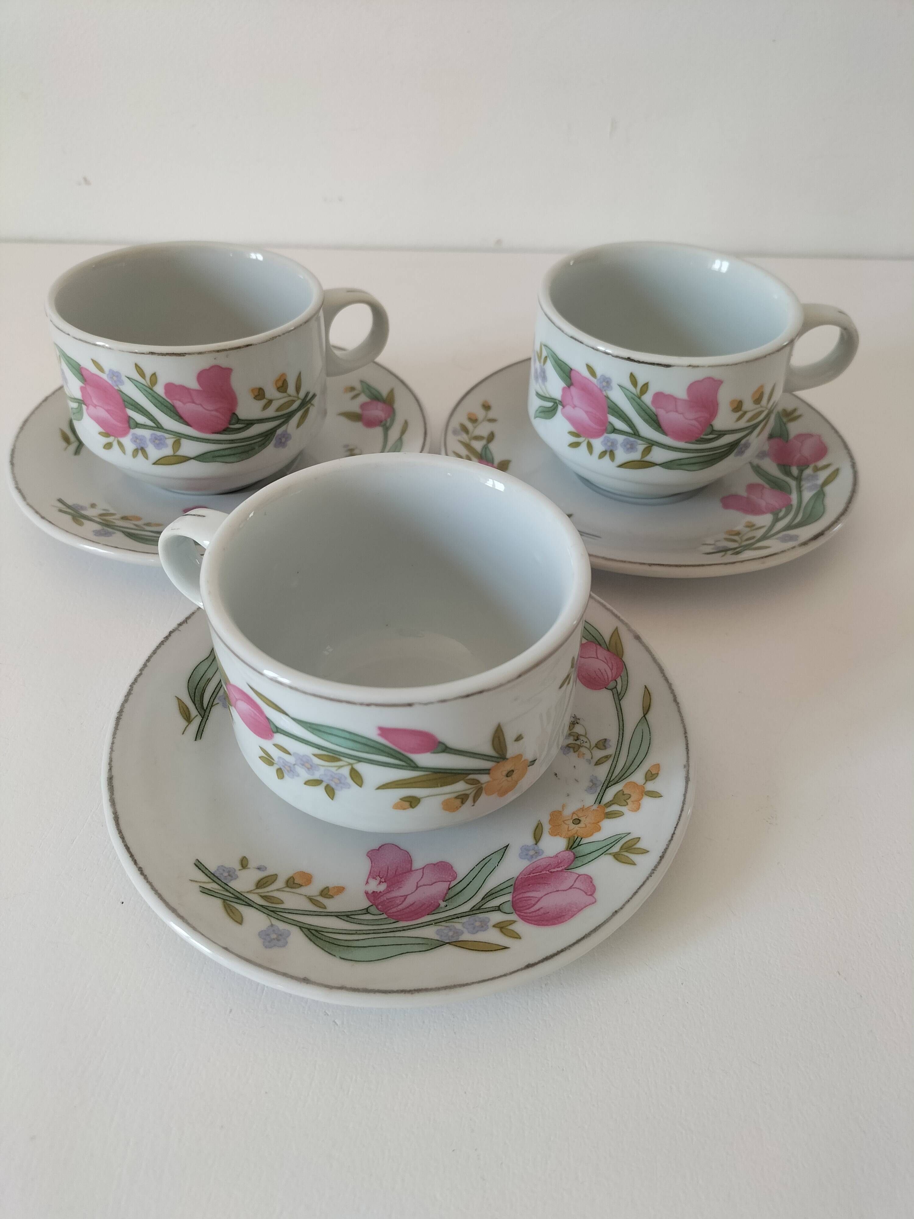 Trio of floral porcelain cups and saucers