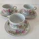 Trio of floral porcelain cups and saucers