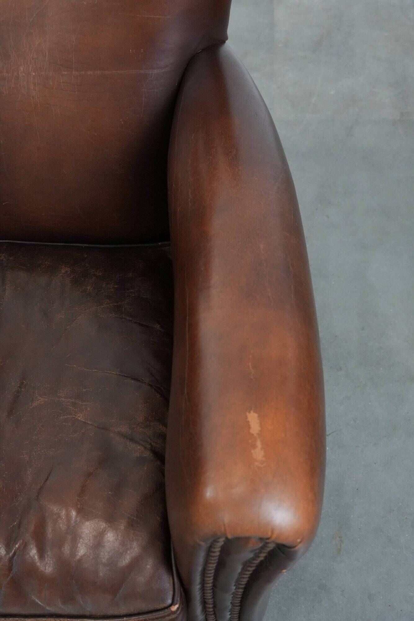 Ensemble de deux fauteuils en cuir de mouton vintage au caractère marqué.