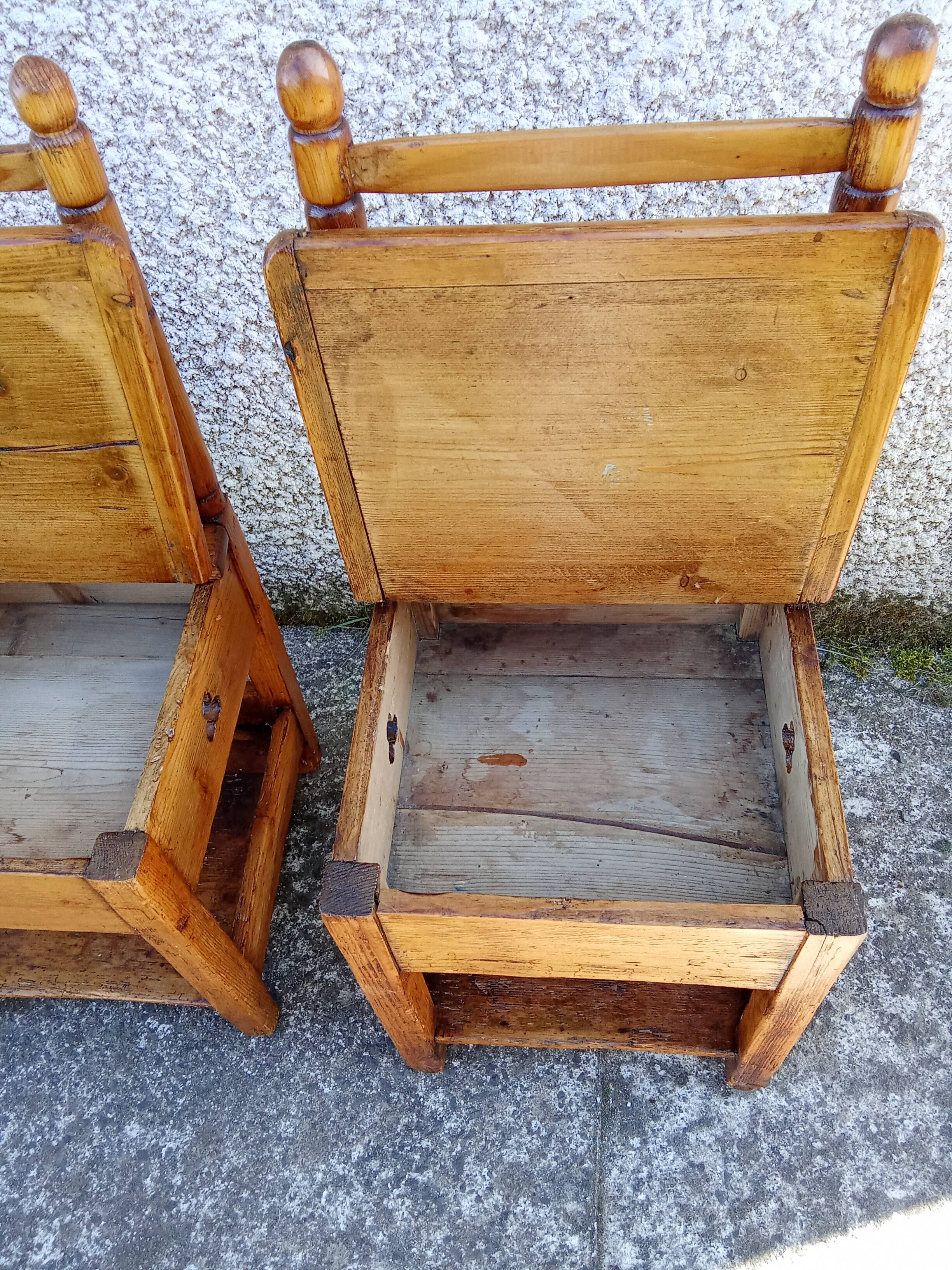 2 old wooden children's chairs with a small chest.