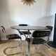 Set consisting of a table in chrome and smoked glass and its 4 tubular chairs in chrome and skaï a