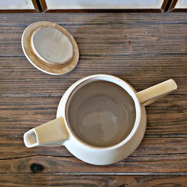 Vintage round ceramic teapot in cream colour, art deco style.