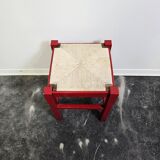 Red wooden stool with woven rush seat.