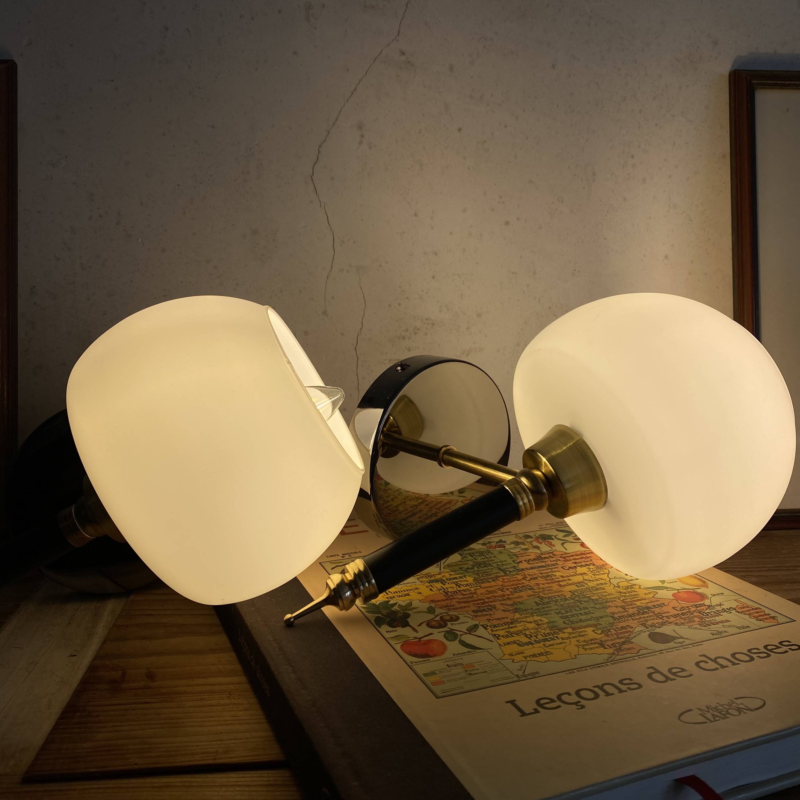 Pair of wall sconces with brass torch and white glass globe.