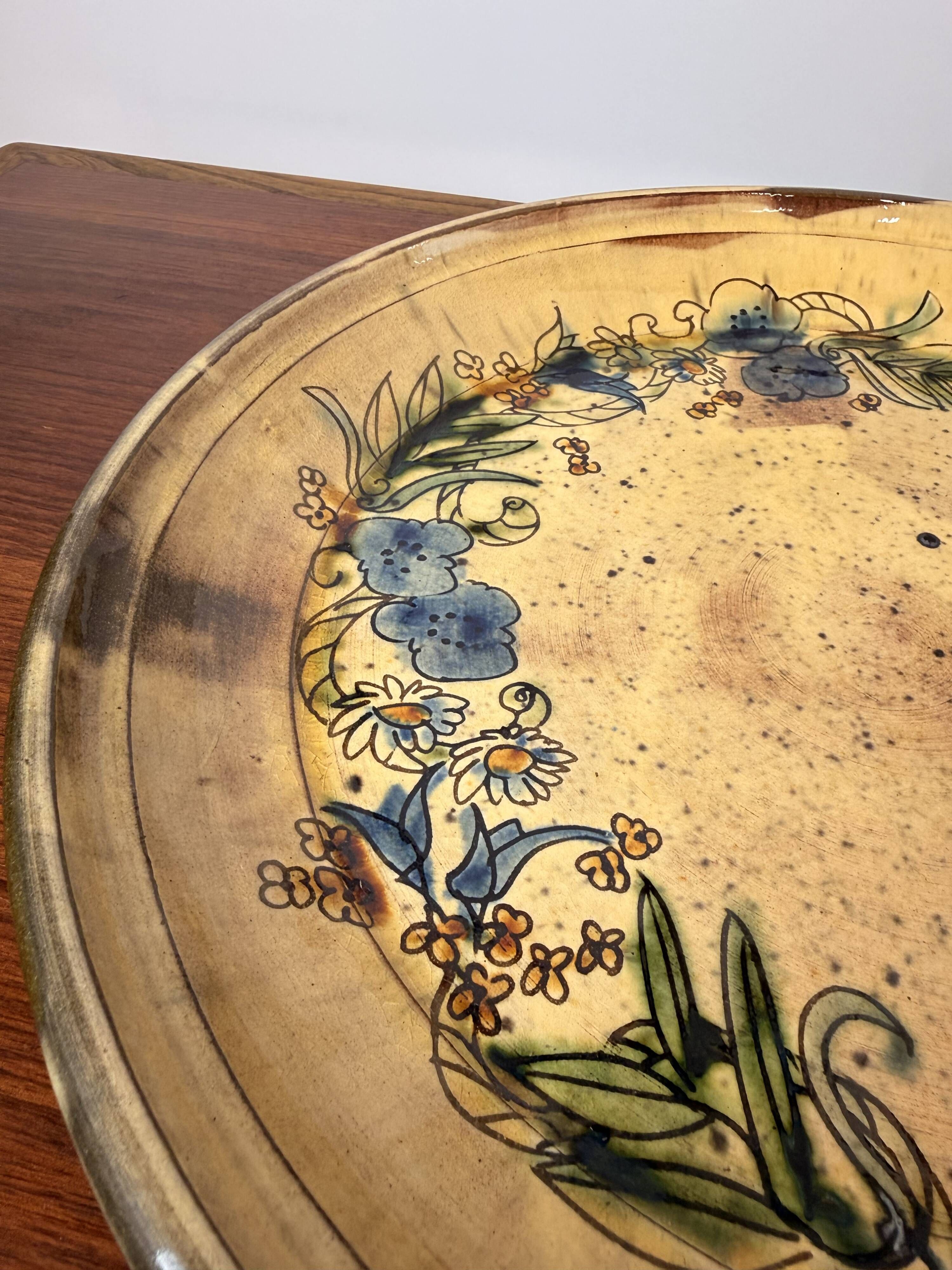 Vintage round ceramic plate with floral decoration.