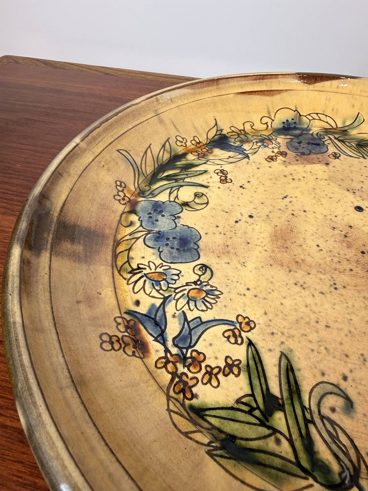 Vintage round ceramic plate with floral decoration.